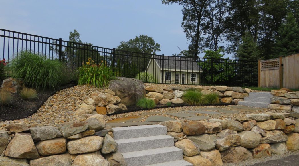 Retaining wall installation in Andover MA transforming a sloped yard with durable landscaping design